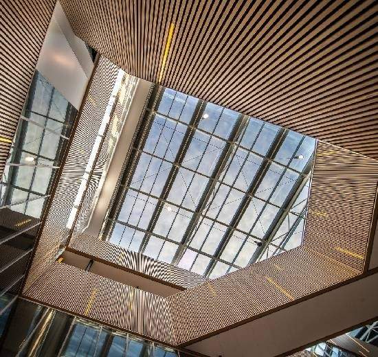 Modern architectural interior with glass skylight and wooden ceiling design